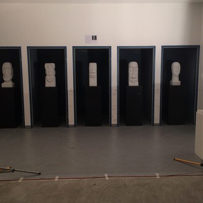 Kopf-Skulpturen in den Telefonzellen der ehemaligen Post